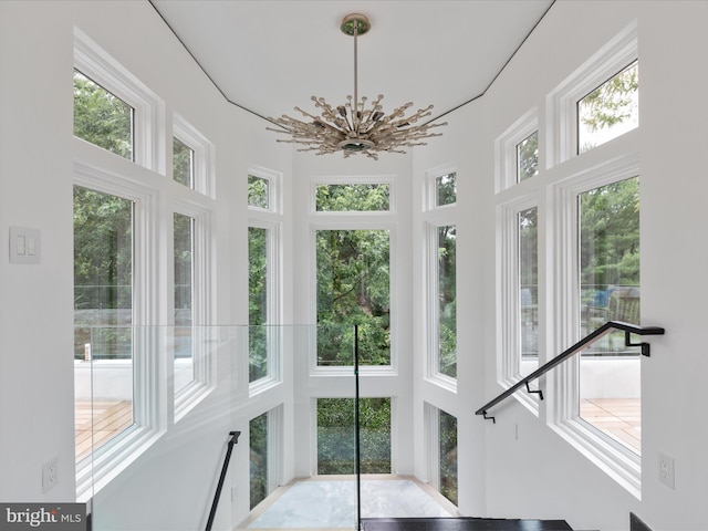 sunroom / solarium with a chandelier and a healthy amount of sunlight