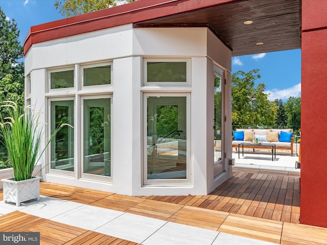 doorway to property with an outdoor hangout area and a wooden deck