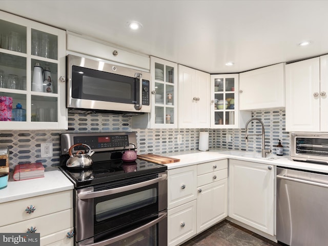 kitchen featuring white cabinetry, appliances with stainless steel finishes, and tasteful backsplash