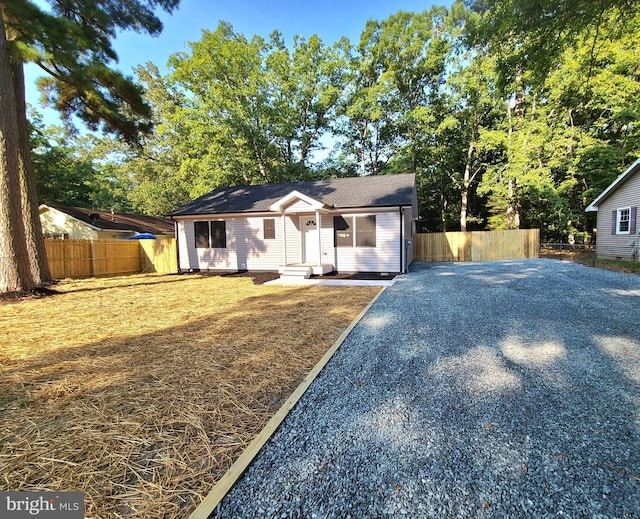 view of front facade featuring driveway and fence