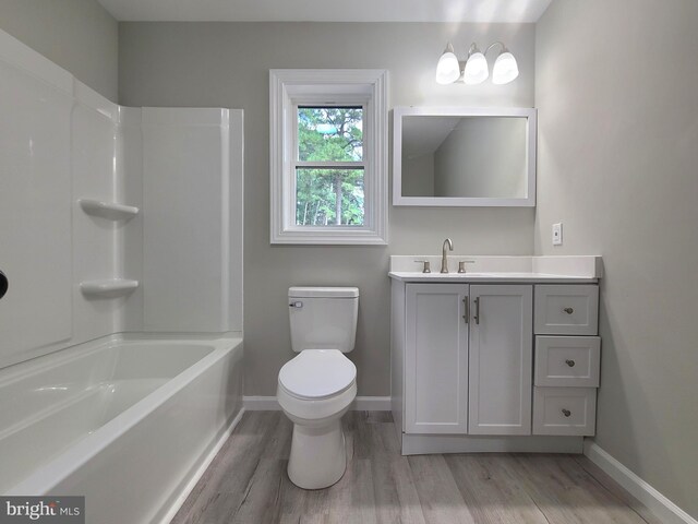 full bathroom with shower / bathing tub combination, hardwood / wood-style floors, vanity, and toilet