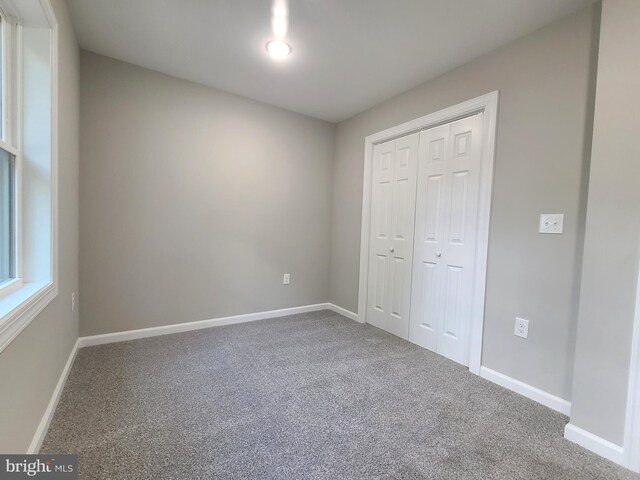 unfurnished bedroom featuring carpet flooring and a closet