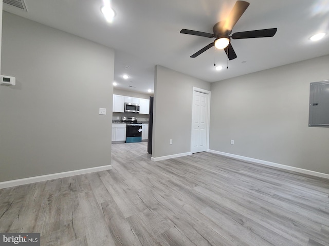 unfurnished living room featuring electric panel, light hardwood / wood-style flooring, and ceiling fan