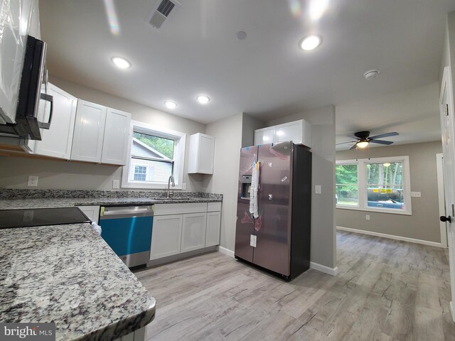 kitchen with white cabinets, sink, ceiling fan, light hardwood / wood-style floors, and stainless steel appliances