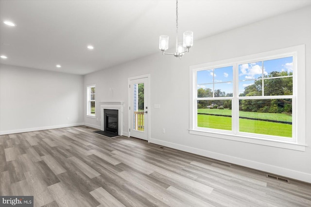 unfurnished living room featuring light hardwood / wood-style floors and a notable chandelier