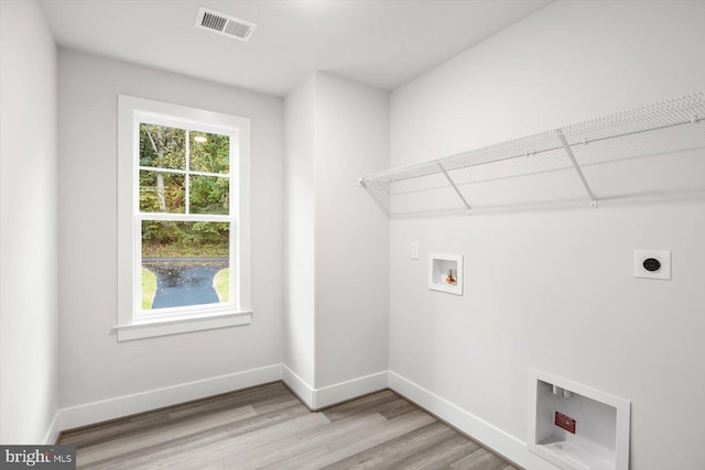 laundry area featuring washer hookup, light hardwood / wood-style flooring, and hookup for an electric dryer