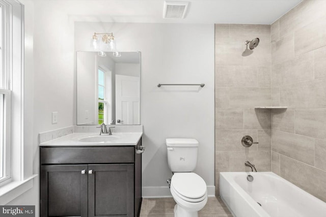 full bathroom featuring toilet, tiled shower / bath combo, and vanity