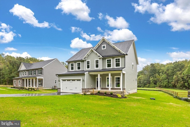 view of front of home with a garage, a front yard, and a porch