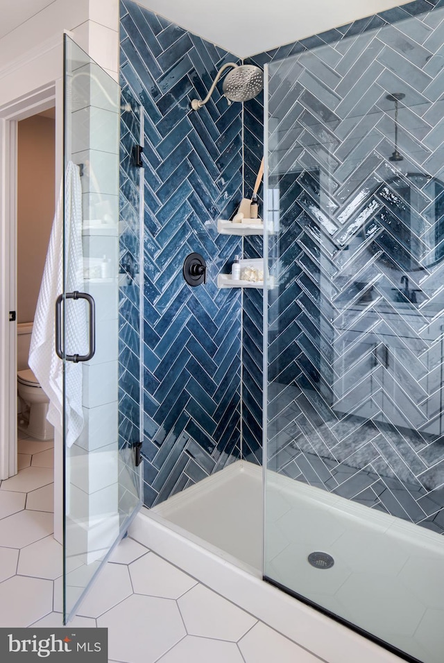 bathroom with a stall shower, tile patterned flooring, and toilet