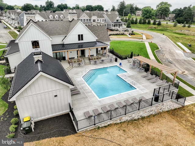 community pool with a patio area and fence