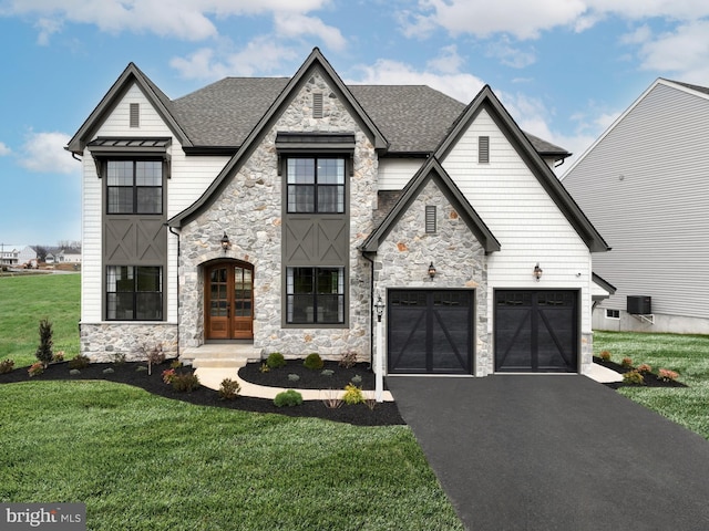 view of front facade featuring a front lawn, a garage, and french doors