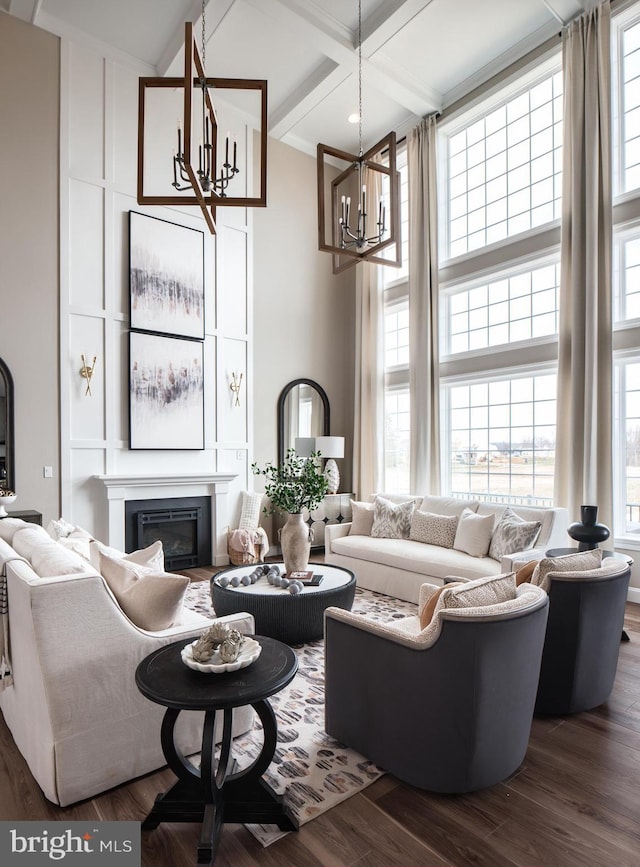 living room featuring beamed ceiling, dark hardwood / wood-style floors, a high ceiling, and coffered ceiling