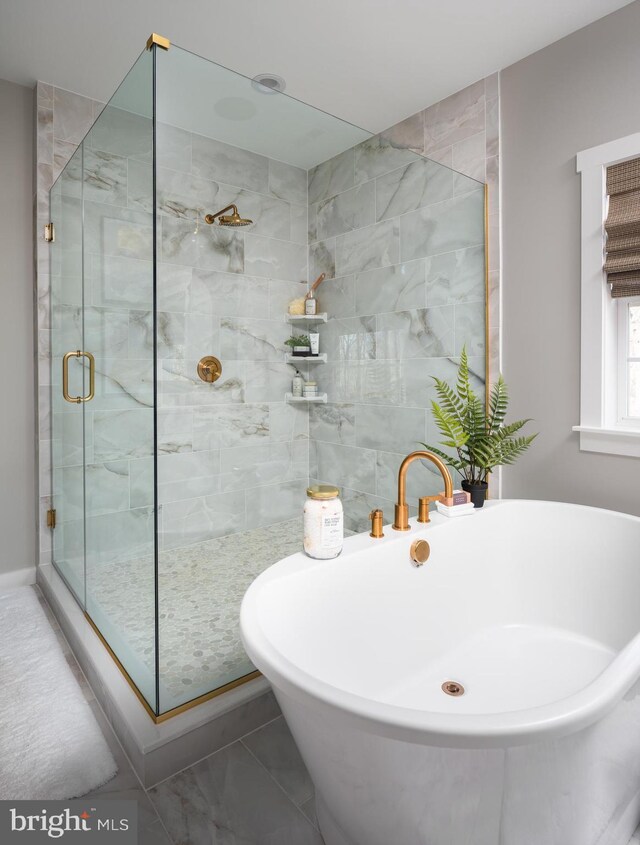 full bath with a shower stall, marble finish floor, and a soaking tub