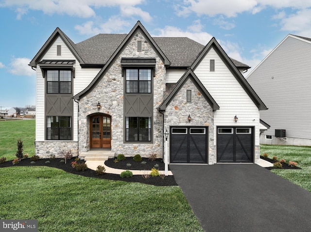 view of front of property featuring a garage, a front lawn, and french doors