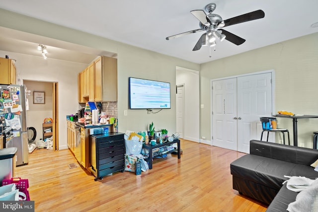 living room with ceiling fan and light hardwood / wood-style floors