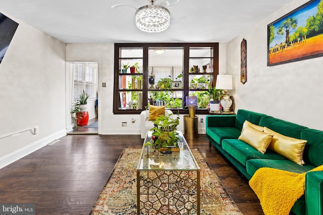 living room with dark hardwood / wood-style flooring and a notable chandelier