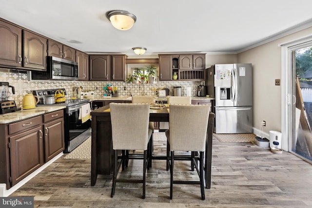 844 Cumberland St, Gloucester City, NJ 08030 - kitchen with appliances with stainless steel finishes, a breakfast bar, dark brown cabinetry, and backsplash