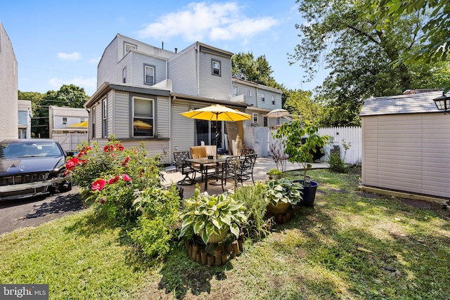 back of property featuring a patio, a lawn, and a storage unit