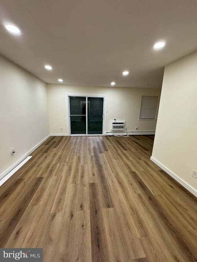 unfurnished living room featuring hardwood / wood-style floors and a wall mounted AC