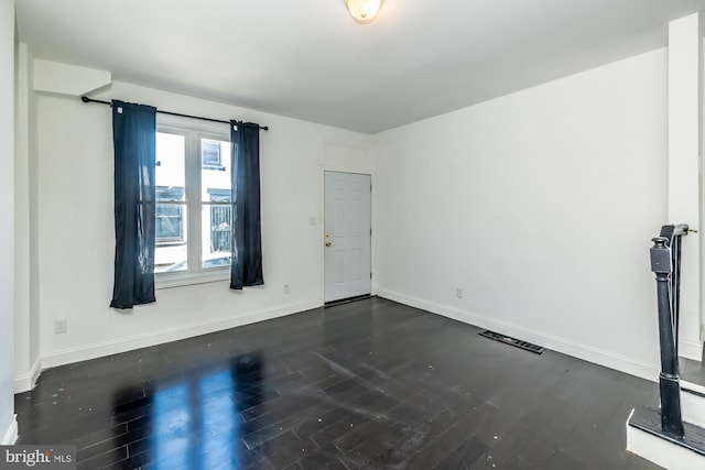 unfurnished room featuring dark wood-type flooring