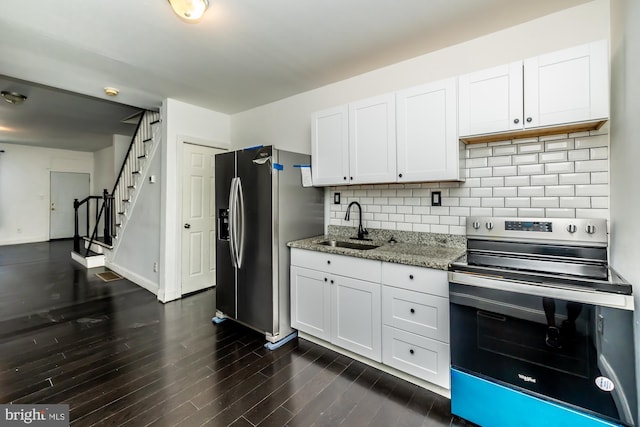 kitchen featuring sink, backsplash, stainless steel appliances, light stone counters, and white cabinets