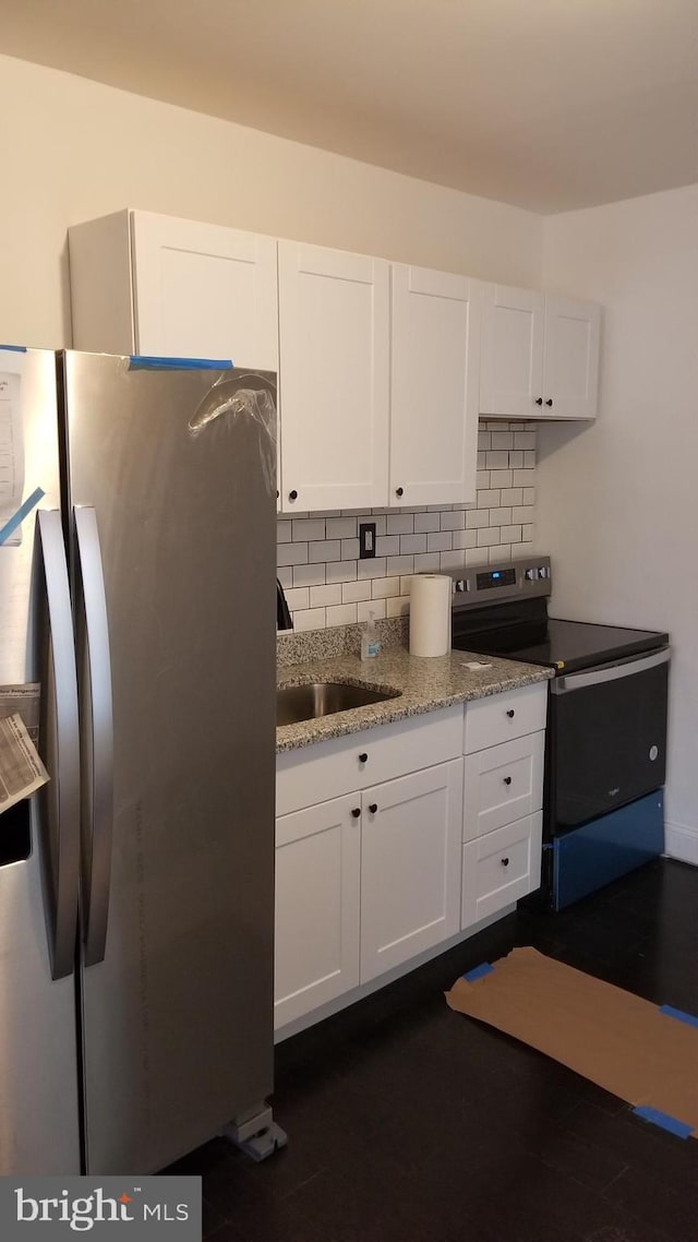 kitchen featuring stainless steel appliances, white cabinetry, tasteful backsplash, and sink