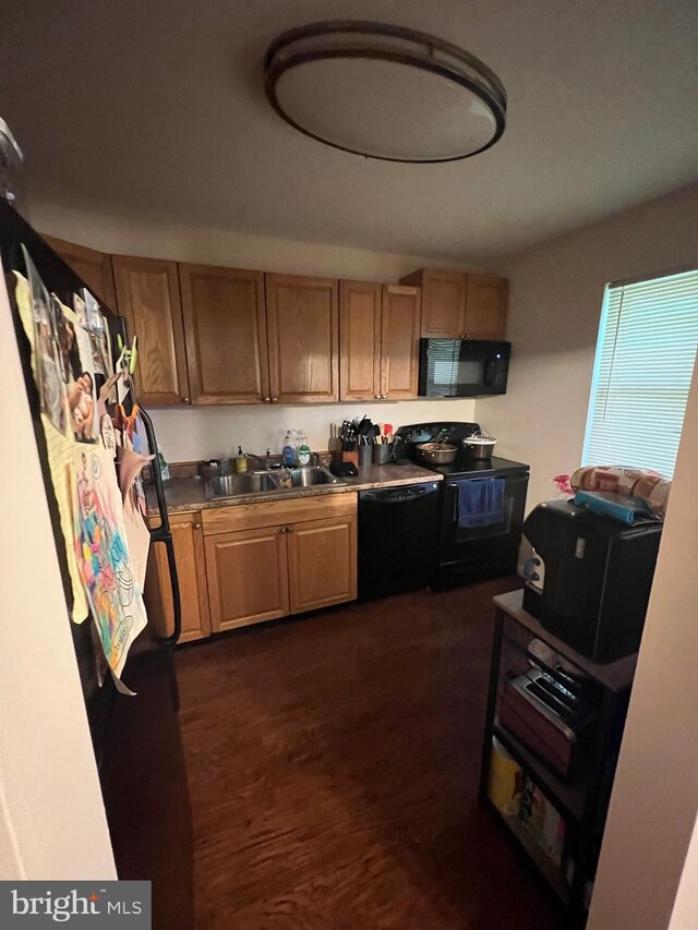 kitchen with dark wood-type flooring, sink, and black appliances