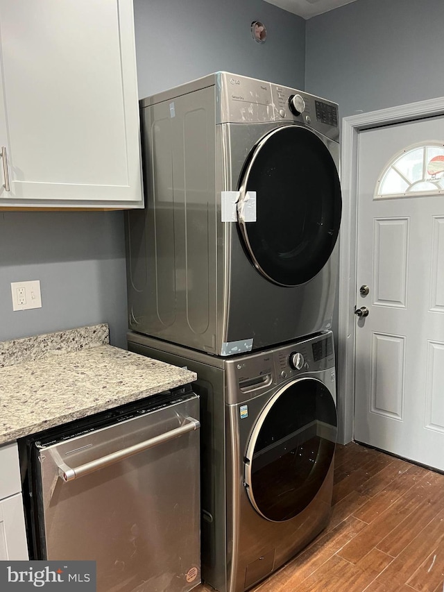 clothes washing area with light wood-type flooring and stacked washer / dryer