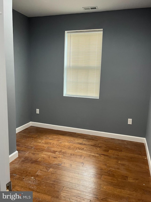 unfurnished room with hardwood / wood-style flooring