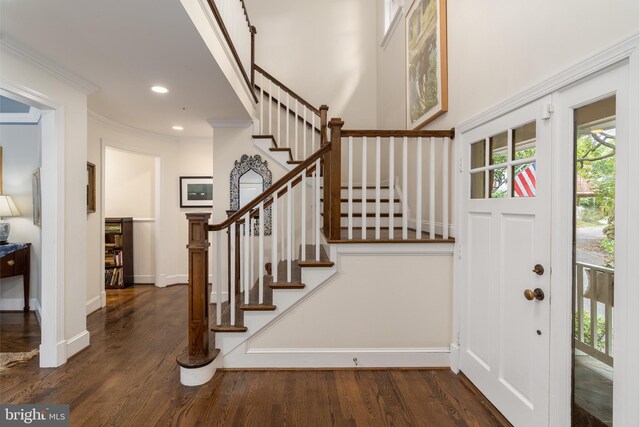 foyer with recessed lighting, crown molding, baseboards, and wood finished floors