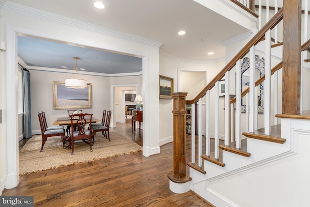 interior space with dark wood-type flooring, recessed lighting, ornamental molding, and stairway