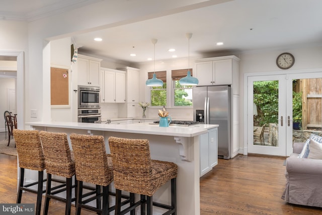 kitchen featuring dark wood-style flooring, stainless steel appliances, crown molding, light countertops, and white cabinetry