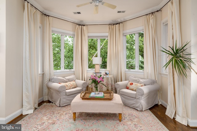 sitting room with a ceiling fan, visible vents, baseboards, and wood finished floors