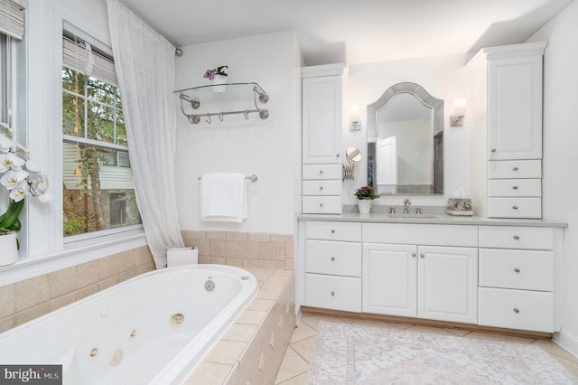 bathroom with a jetted tub, vanity, and tile patterned floors