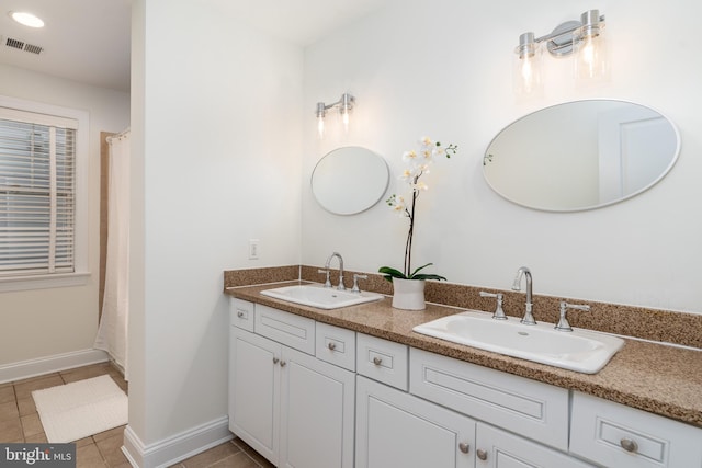 bathroom with tile patterned flooring, a sink, visible vents, and baseboards