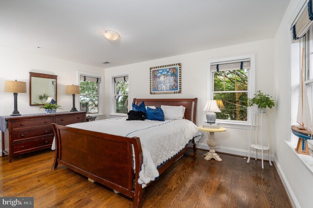 bedroom featuring visible vents, baseboards, and dark wood-type flooring