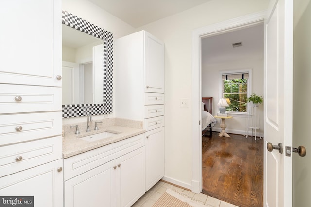 bathroom with wood finished floors, vanity, and baseboards