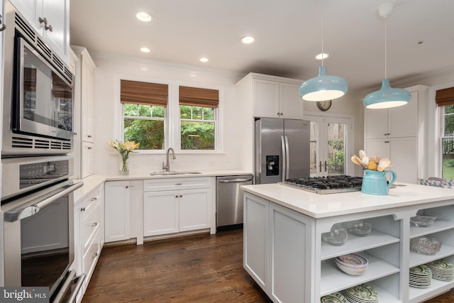 kitchen featuring crown molding, appliances with stainless steel finishes, a sink, and white cabinets