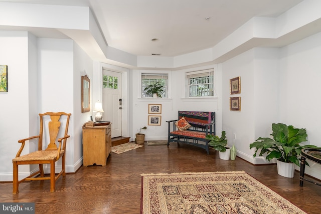 living area featuring a wealth of natural light, visible vents, baseboards, and wood finished floors