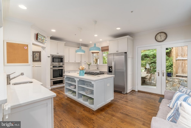 kitchen featuring stainless steel appliances, a sink, white cabinetry, light countertops, and open shelves