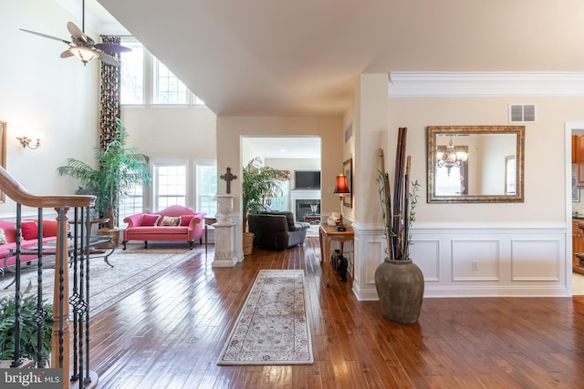 entrance foyer with ceiling fan, ornamental molding, and dark hardwood / wood-style flooring