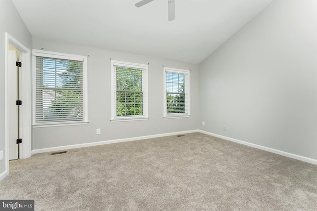 spare room featuring lofted ceiling, light carpet, and ceiling fan