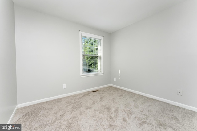 spare room featuring light colored carpet