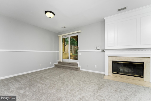 unfurnished living room featuring light carpet and a premium fireplace