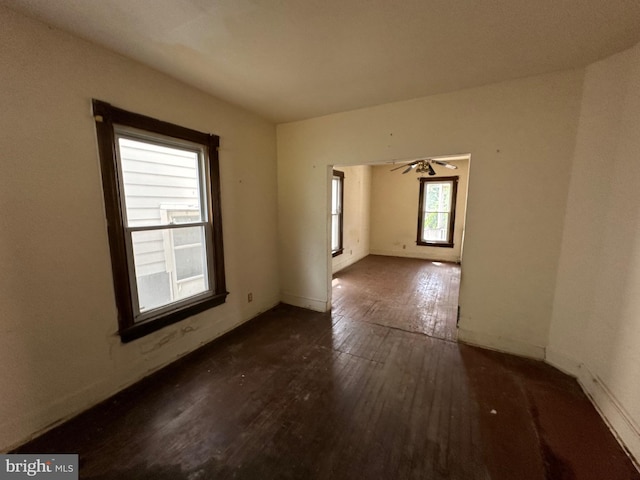 empty room with ceiling fan and dark hardwood / wood-style flooring