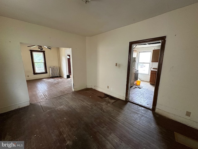 spare room with ceiling fan, hardwood / wood-style flooring, and radiator heating unit