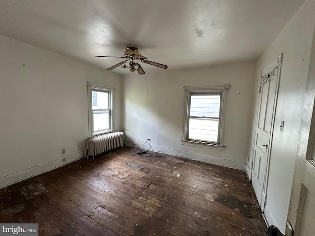 spare room featuring ceiling fan, plenty of natural light, radiator heating unit, and dark hardwood / wood-style floors