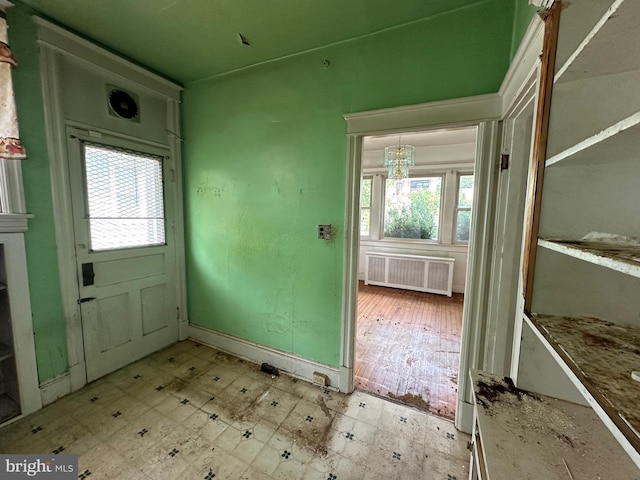 doorway to outside featuring radiator heating unit and a notable chandelier