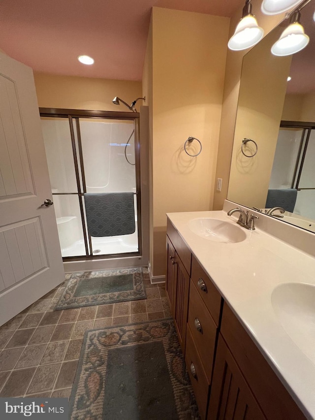 bathroom with vanity and a shower with door