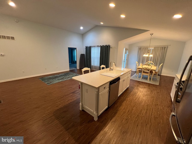 kitchen with lofted ceiling, a center island with sink, stainless steel dishwasher, decorative light fixtures, and white cabinetry